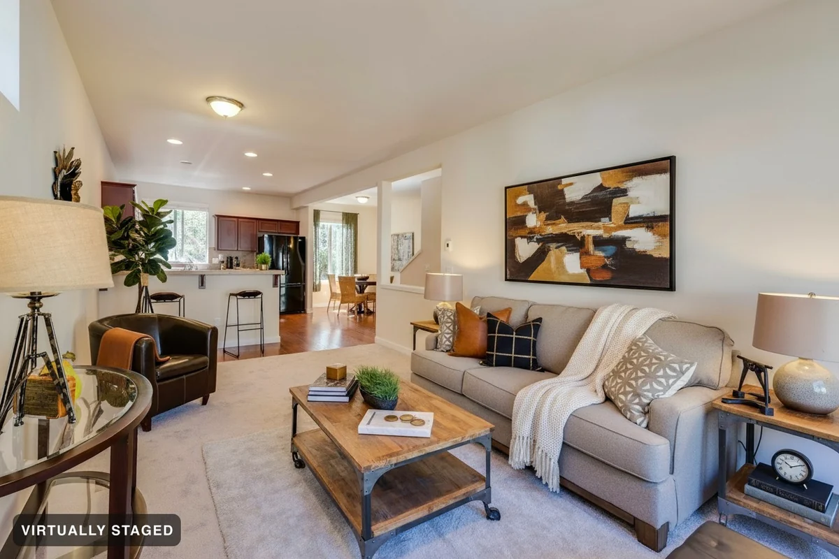 The same room with cushions, a knit throw, a fig tree, coffee-table styling and new wall art added — the sofa, leather chair, coffee table and side tables have not moved