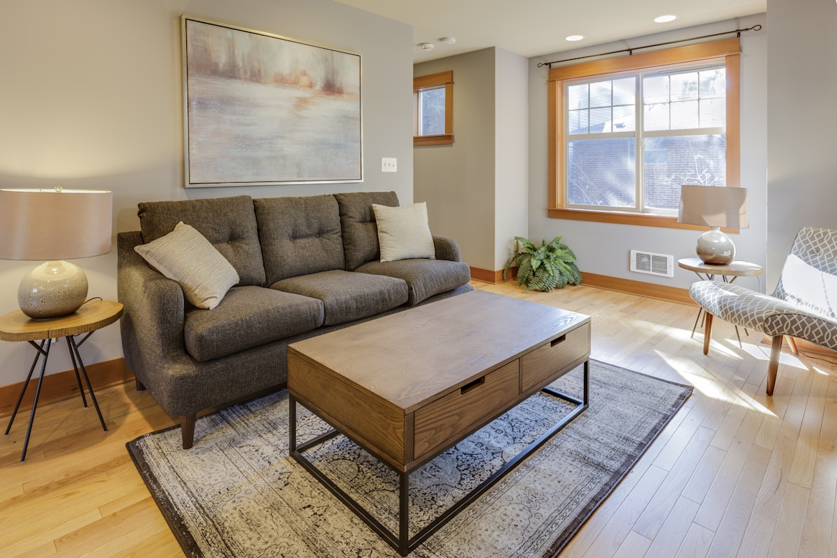 A living room as photographed, with the seller's grey sofa, coffee table and rug